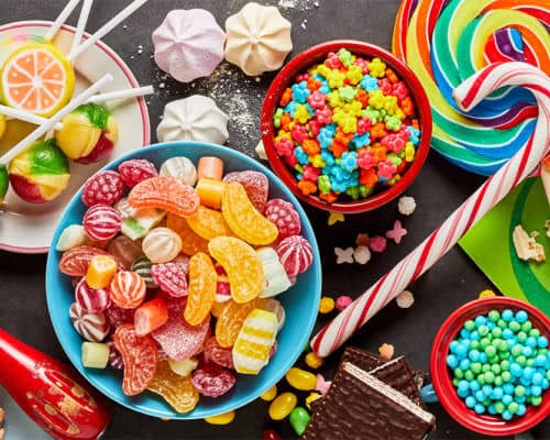 Brightly coloured sweets laid out on black background