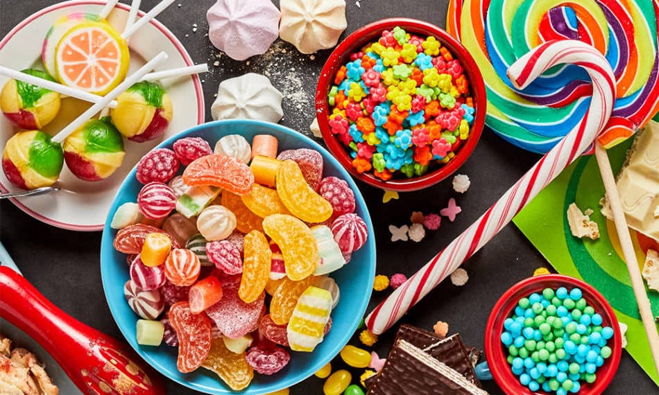 Brightly coloured sweets laid out on black background