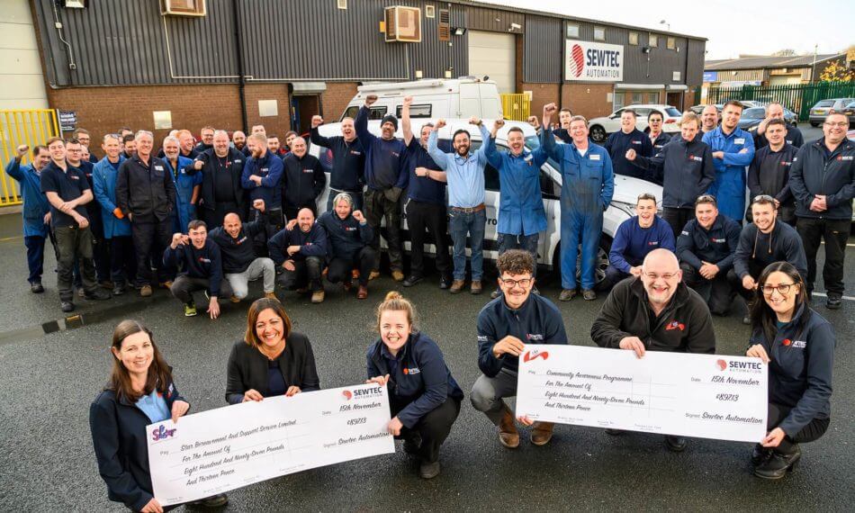 Full team photo holding two cheques