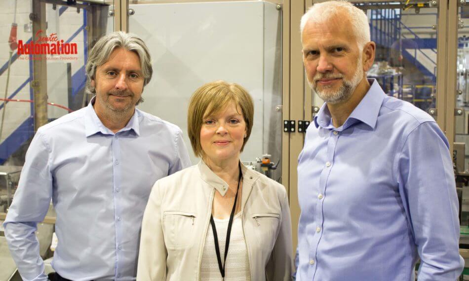 Two males and a female smiling in front of a camera