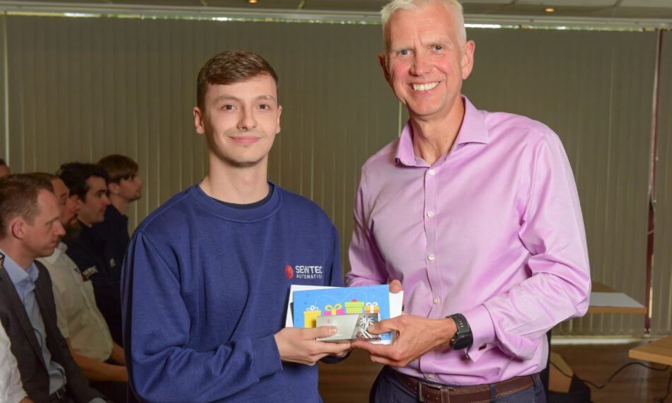 Two males smiling at camera holding award