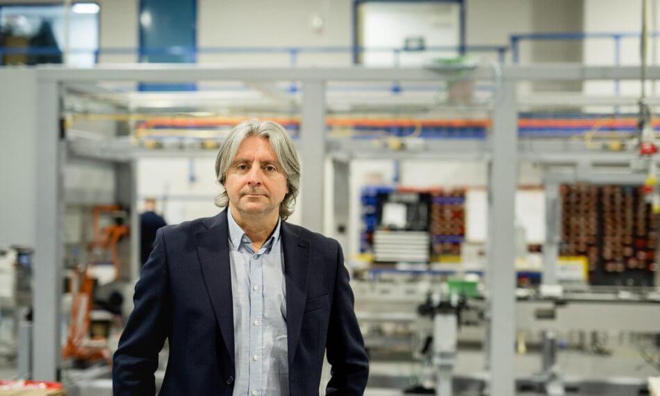 Male looking at camera, stood in front of machinery