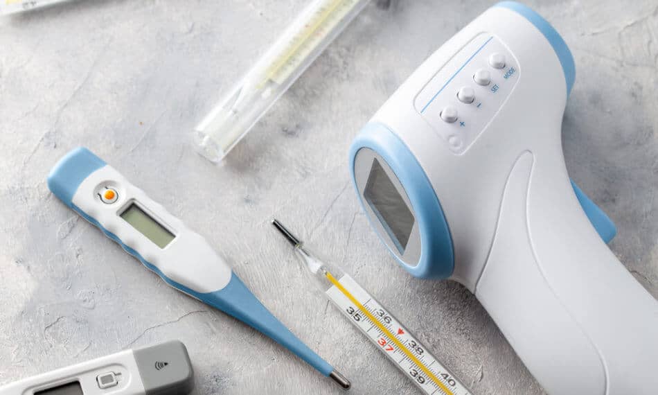 Medical equipment including a thermometer laid out on table