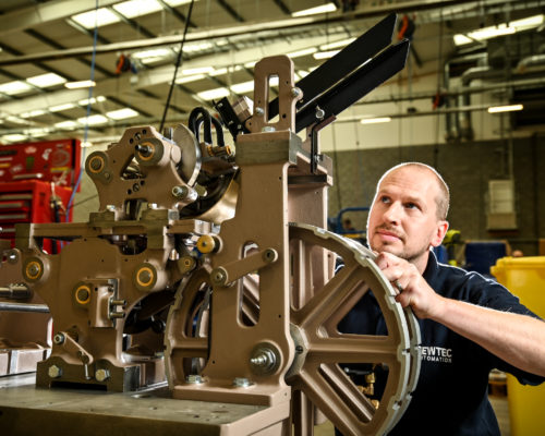 Male employee adjusting automated machinery