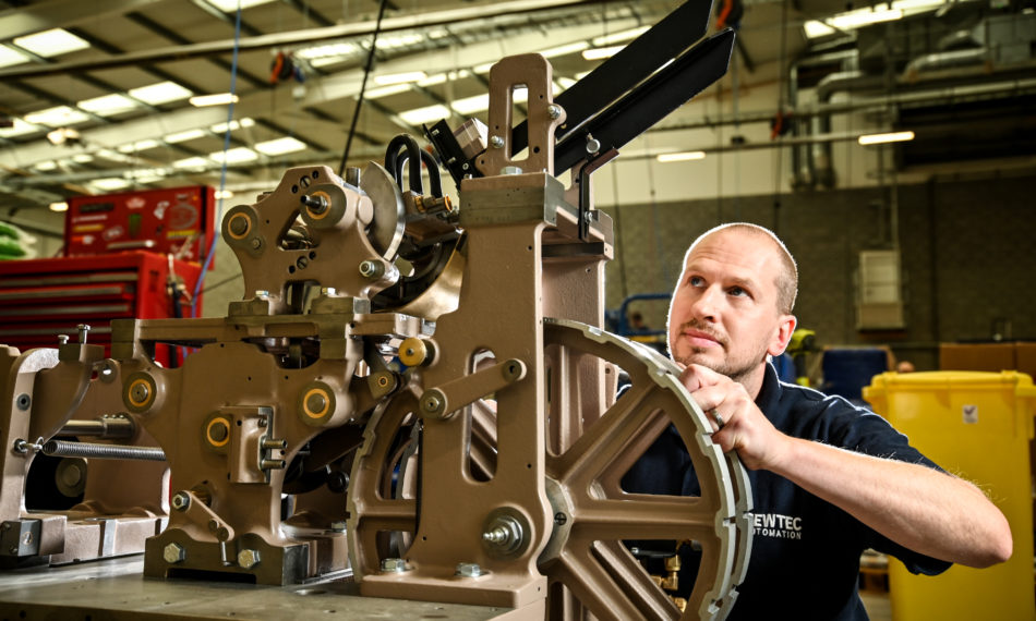 Male employee adjusting automated machinery