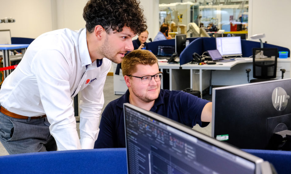 Two male employees looking at computer screen