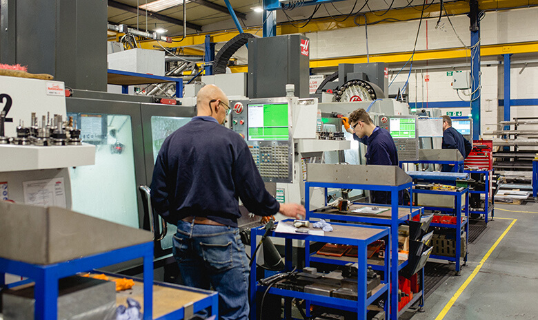 Three male employees working with machinery