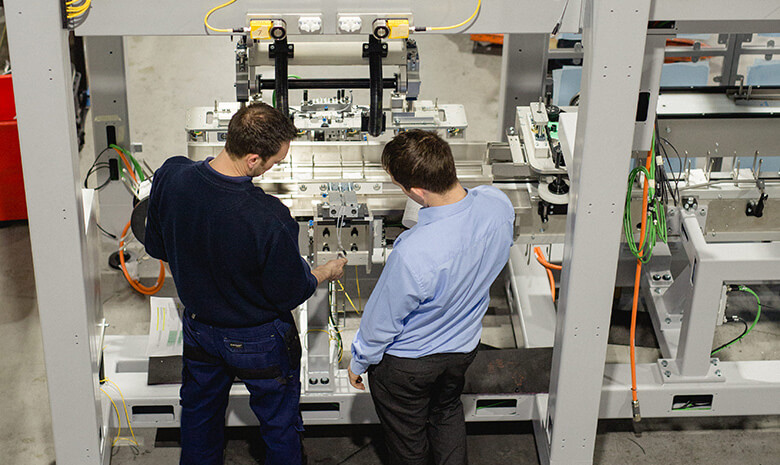 Two males adjusting machinery
