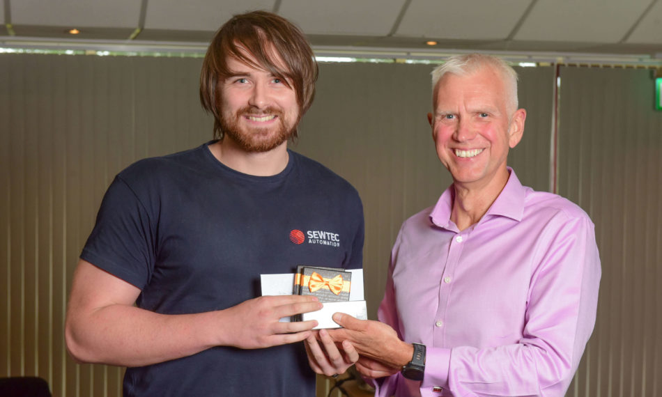 Two males smiling at the camera holding an award