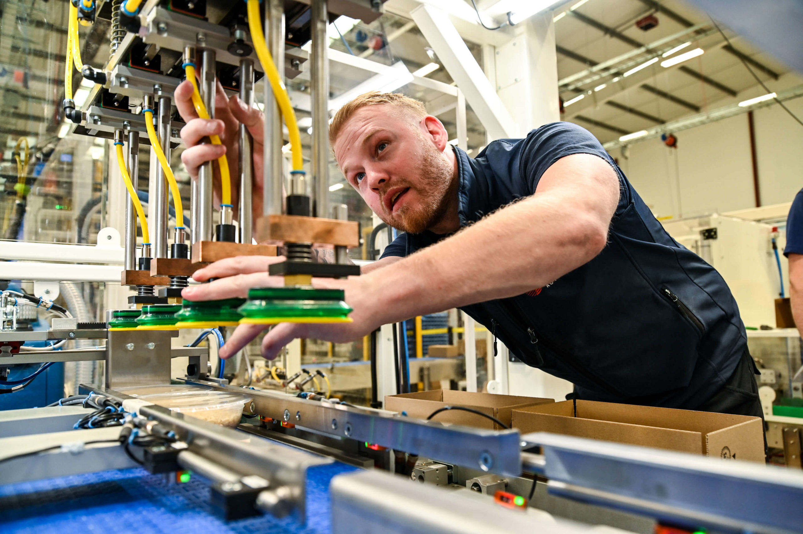 An employee adjusting an robotic machine