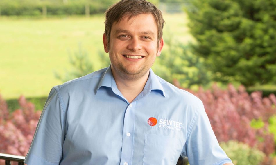 Male employee smiling at camera in an outdoor setting