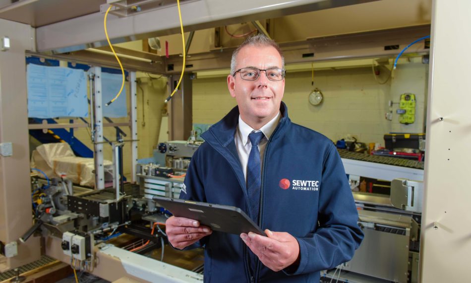 Male employee smiling at camera with a click board